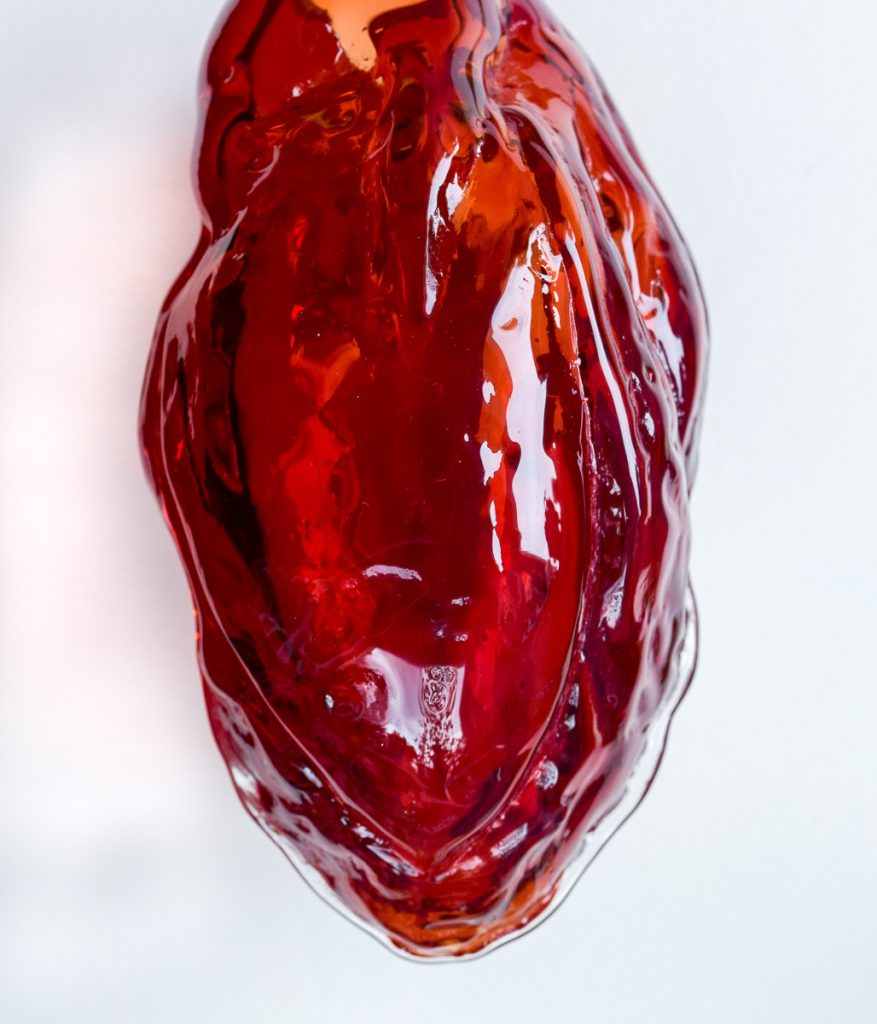 Art piece "The Eternal Debate of the Unconcious Mind" in 2016 by Alise Stopina. Blood red heart shaped blown glass, with heart beat pulsiating red light in them. On white background to show glass work.
