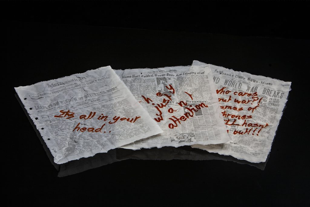 Art piece "Insert Sarcastic Title Here" in 2018 by Alise Stopina. White glass powder with printed text and hand written red satarical quotes. Black background and unbound from book.